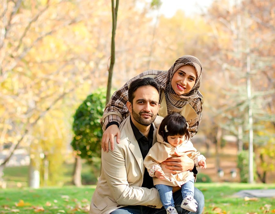 Young family with mother in hijab and toddler in a park
